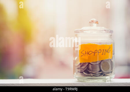 Saving money for Shopping budget, Coins keeping in glass bottle with blur background space for text Stock Photo