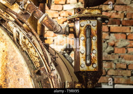 Rusted liquid meter of an ancient machine in a abandoned factory Stock Photo