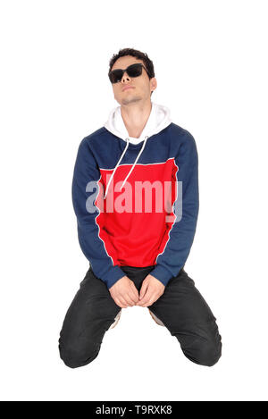 A handsome young man wearing sunglasses kneeling on the floor in sports clothing, taking a rest, isolated for white background Stock Photo