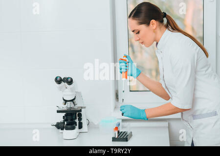 Scientist working with blood at laboratory. Blood research Stock Photo