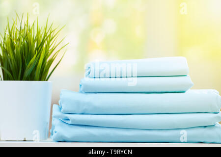 Closeup stack of blue clean bedding on blurred background. Stock Photo
