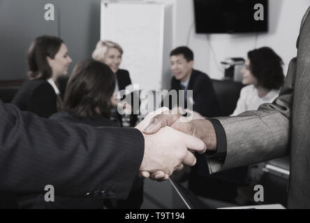 Closeup of businessmen handshake as sign of closing deal on meeting Stock Photo
