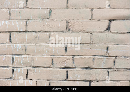 Old painted beige color weathered stained brick wall for texture or background Stock Photo