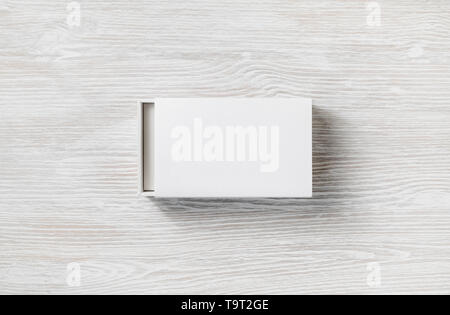 White cardboard sliding open box on light wooden background. Flat lay. Stock Photo