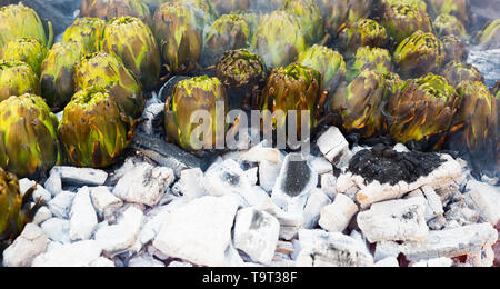 Closeup of artichokes being grilled on ember. Healthy outdoor eating Stock Photo