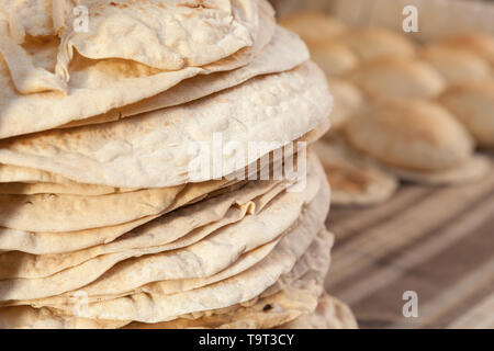 https://l450v.alamy.com/450v/t9t3cy/homemade-kuboos-stacked-traditional-pitta-bread-lie-on-a-counter-of-street-market-in-egypt-t9t3cy.jpg