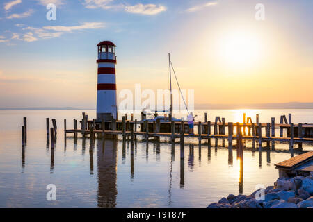 Lighthouse at Lake Neusiedl, Podersdorf am See, Burgenland, Austria. Lighthouse at sunset in Austria. Wooden pier with lighthouse in Podersdorf on lak Stock Photo