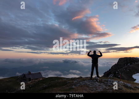 Hiker watching sunset high up in the Alps Stock Photo