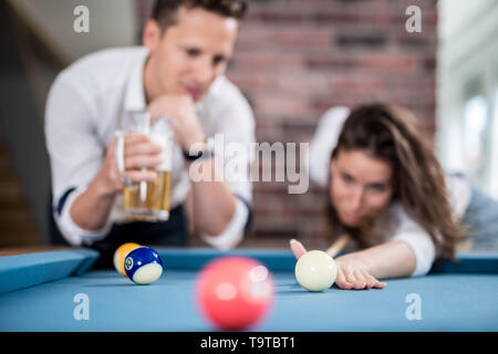 Couple playing snooker game and drinking beer. Stock Photo