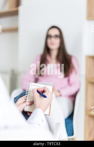 Close up of female hand holding notepad and taking notes on job interview. Stock Photo