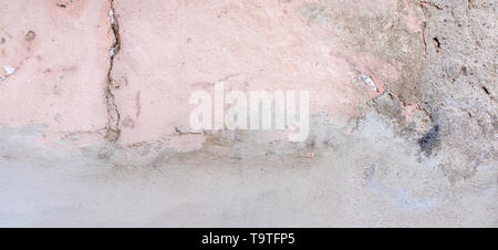 Old weathered painted wall background texture. White and pink dirty peeled plaster wall with falling off flakes of paint Stock Photo