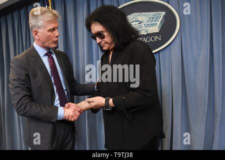 U.S. Assistant to the Secretary of Defense for Public Affairs Charles E. Summers Jr. left, shakes hands with rock legend Gene Simmons of KISS during a meet-and-greet at the Pentagon May 16, 2019 in Washington, D.C. Stock Photo