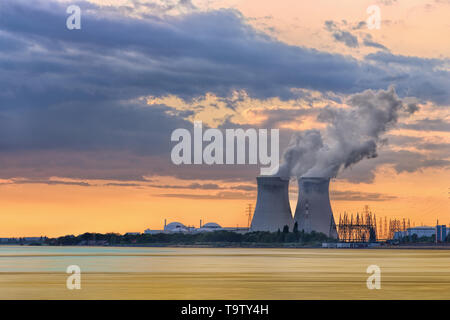 Riverbank with nuclear power plant Doel during a sunset with dramatic clouds, Port of Antwerp, Belgium Stock Photo