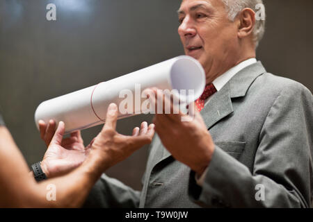 Architect handing blueprints to businessman. Stock Photo
