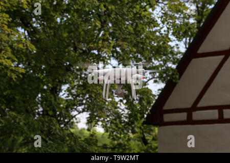 Flying quadcopter with digital camera on blurred background. Stock Photo