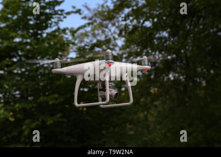 Flying quadcopter with digital camera on blurred background. Stock Photo