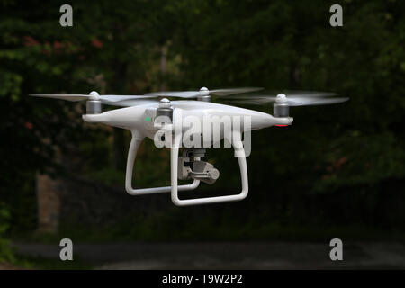 Flying quadcopter with digital camera on blurred background. Stock Photo