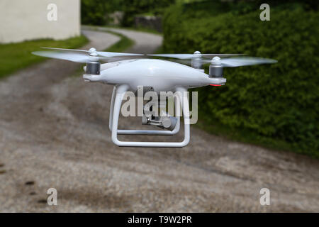 Flying quadcopter with digital camera on blurred background. Stock Photo