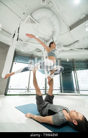 Strong sport couple practicing fitness yoga in spacious room Stock Photo