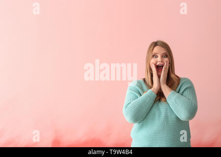 Surprised plus size girl on color background. Concept of body positivity Stock Photo