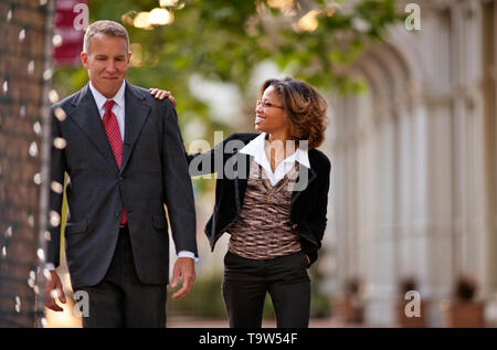 Co-workers walking together happily on sidewalk. Stock Photo
