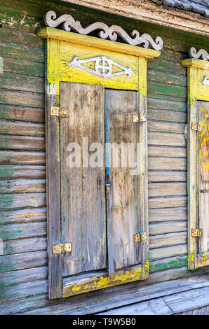 Russian traditional wooden architecture. Wooden shutters on the windows of the old house Stock Photo