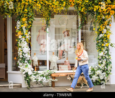 London, UK. 20th May, 2019.Belgravia, London, UK, 20th May 2019. A woman walks along a pretty flower display at Pepa & Co.  Belgravia's fourth annual floral festival coincides with the RHS Chelsea Flower Show in neighbouring Chelsea. This year, the theme of ‘The Language of Flowers’ invites the visitor to uncover the secret meanings behind flowers. Credit: Imageplotter/Alamy Live News Stock Photo