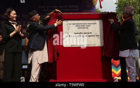 (190521) -- DHADING, May 21, 2019 (Xinhua) -- Nepali Prime Minister KP Sharma Oli (2nd L) unveils a plaque in a ground breaking ceremony of laying the optical fibers at Galchhi Rural Municipality of Dhading District, in Western Kathmandu, May 20, 2019. China Communications Services International Limited started to lay optical fibers along a highway connecting the eastern and western border of Nepal for Nepal Telecom (NT), one of the biggest telecom service providers of Nepal. The Chinese company is responsible for laying 555 kilometers of optical fibers out of the planned 2,179-km long fibe Stock Photo