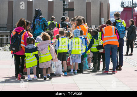 New Brighton, Wallasey. 21st May, 2019. UK Weather: Bright and sunny on the wirral riverside as pre-school children enjoy an escorted walk on the seafront promenade. Each child wearing a hi-vis tabard printed 'Slow down for Bobby' Twenty's Plenty; The Bobby Colleran Trust is Road Safety Charity offering advice and guidance for Parents and Schools. Since Bobby’s accident, his family have campaigned for safer roads outside all schools. Credit; MediaWorldImages/AlamyLiveNews. Stock Photo