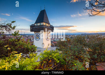 Classic panorama view of the historic city of Graz with famous Grazer Uhrturm clock tower in beautiful evening light at sunset, Styria, Austria Stock Photo