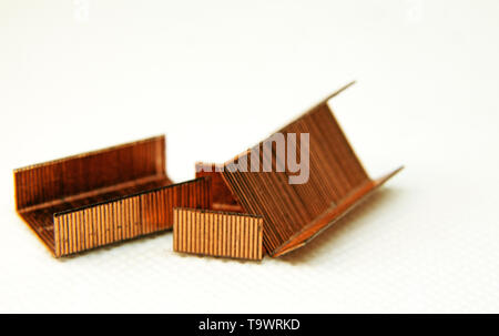 bronze colored staples on white background Stock Photo