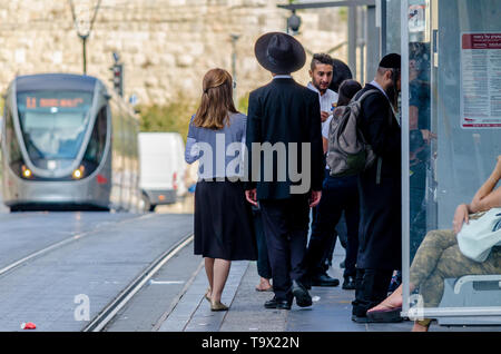 Jerusalem,Israel- August 17, 2016: Jewish Orthodox man and woman waiting for the train at City Hall stop near Jaffa Gate in the Old City of Jerusalem, Stock Photo