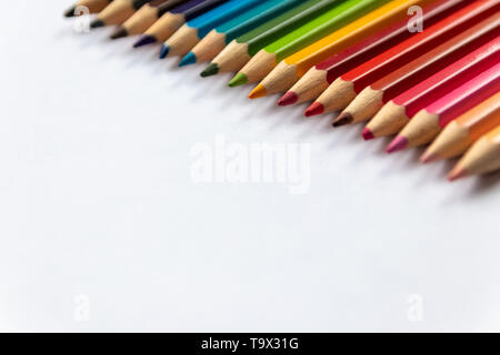 Set of colored pencils in rainbow colors wait for their first picture with a pupil, student or drawer as crayon with blue, red and yellow Stock Photo
