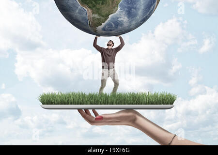Female hand with small man in casual clothes holding earth globe on green grass model with blue sky background