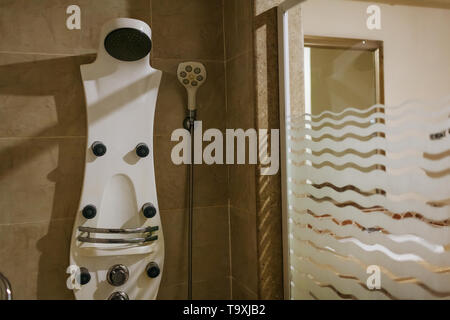 Tiled shower with rain head and glass wall and mirror in hotel bathroom. Modern resort interior Stock Photo