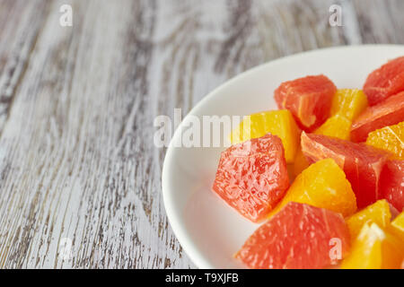 citrus detox salad. colorful tropical and citrus fruits sliced on a plate. country style. copy space. Stock Photo