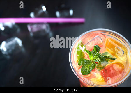 detox lemonade with grapefruit and orange slices with fresh citrus and ice on a black wooden background. view from above. refreshing drink. Stock Photo