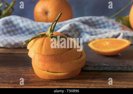 Fresh orange cut into slices on a wooden table. Front view Stock Photo