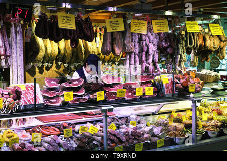 Palma Mallorca, Spain - March 20, 2019 : serrano and iberian iberico ham legs, sausage, chorizo and cheese on display for sale in the local farmers in Stock Photo