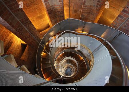 Looking down at a steel Spiral Staircase in Glasgow with glowing warm lighting Stock Photo