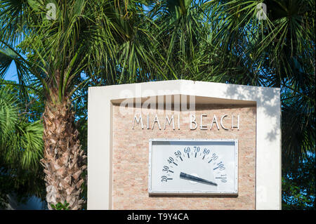 Tropical sun beating down on the landmark Art Deco temperature gauge surrounded by palm trees in Lummus Park, South Beach, Miami's first public park Stock Photo