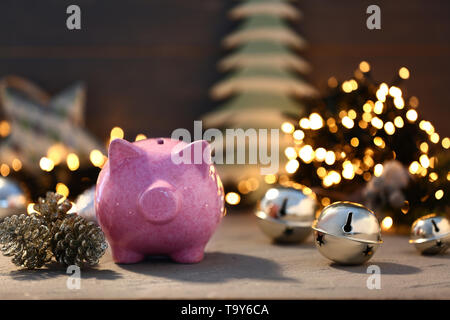Piggy bank with Christmas decor on table Stock Photo
