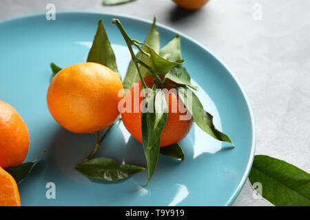Plate with tasty tasty juicy tangerines on table Stock Photo