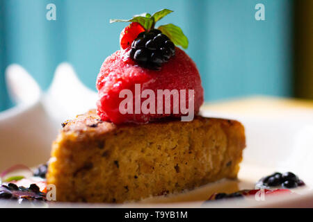 Corn cake with strawberry ice cream and red fruits on top over sweet milk sauce. Stock Photo