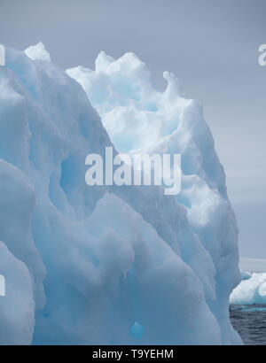 Close up of a light and medium blue iceberg with divots and pock marks floating in the Southern Atlantic Ocean. Stock Photo