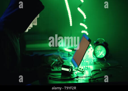 Professional hacker working in dark room Stock Photo