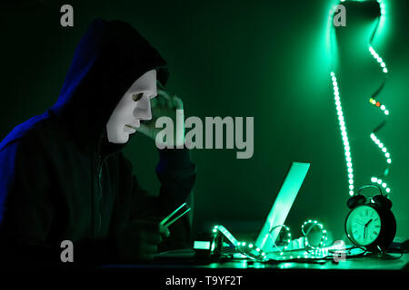 Professional hacker working in dark room Stock Photo