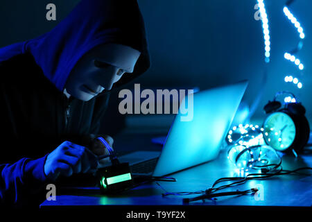 Professional hacker working in dark room Stock Photo