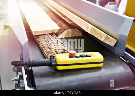 Remote control on a conveyor with boards in a wooden factory Stock Photo