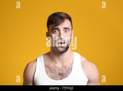 Shocked man having half of his face shaved against color background Stock Photo